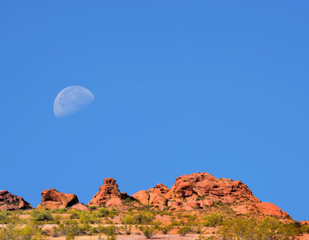 Desert moon over the southwestern USA Sonora desert and mountains with water tanksの写真素材