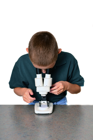 Young boy scientist with microscope examining a sampleの写真素材