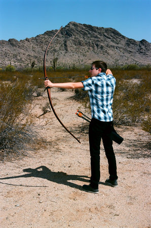 Young archer shooting a traditional long bow