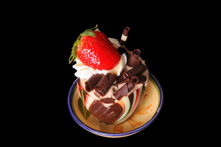 Frozen parfait ice cream and chocolate delight with strawberry isolated over blackの写真素材