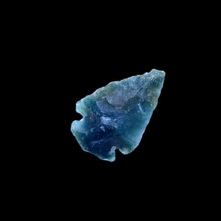 Ancient Prehistoric primitive stone arrowhead isolated over blackの写真素材