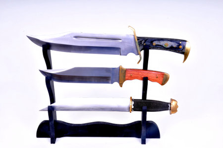 Very large bowie knife and seax isolated over white in display rackの写真素材