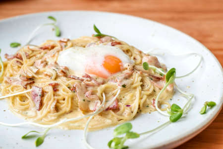 Spaghetti Carbonara with egg on wooden tableの写真素材