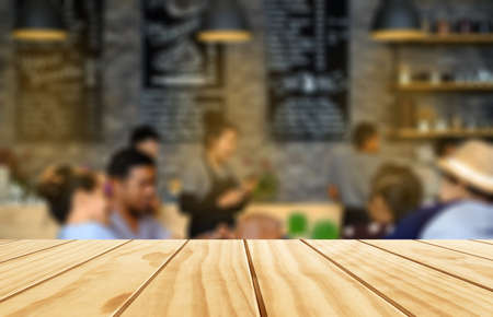 Tip view of empty wooden table for product placement with coffee shop environment background.の写真素材