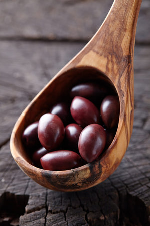 Olives in a wooden spoonの写真素材