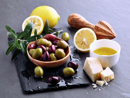 Olives with olive oil on a graphite boardの写真素材