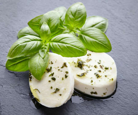 Mozzarella with basil on a black boardの写真素材