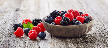 Fresh berries on old wooden board