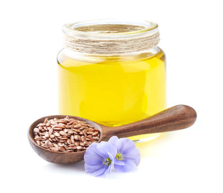 Flax oil with flax seeds in closeup on white backgroundの写真素材