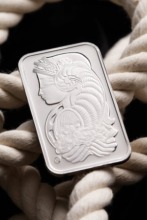 Platinum ingot on white ropeの写真素材