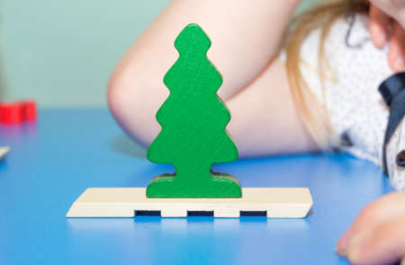 Wooden toy green Christmas tree on a blue tableの写真素材