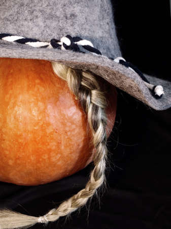 Pumpkin in a hat and with a gray braidの写真素材