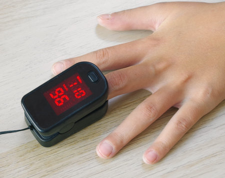 Pulse oximeter on the child's hand. Heart rate and oxygenation measurement