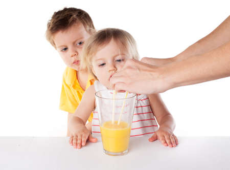 happy children drink orange juice isolated on whiteの写真素材