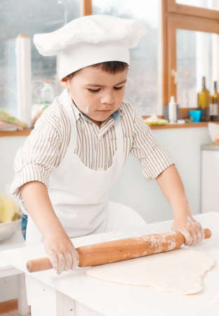 happy little chefs preparing dough in the kitchenの写真素材