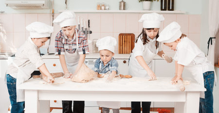 happy little chefs preparing dough in the kitchen
