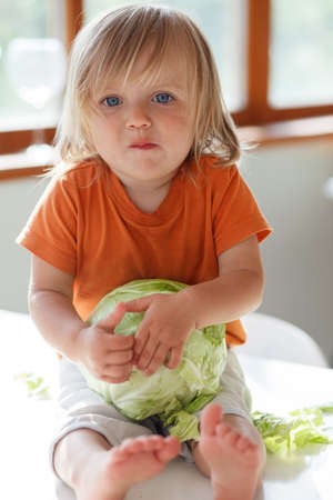 little girl eats cabbageの写真素材