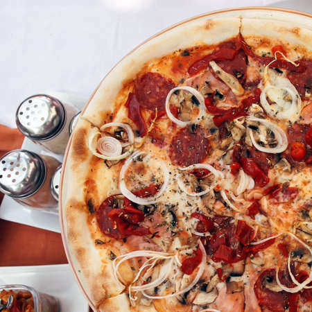 Pizza and slice of pizza on the tableの写真素材