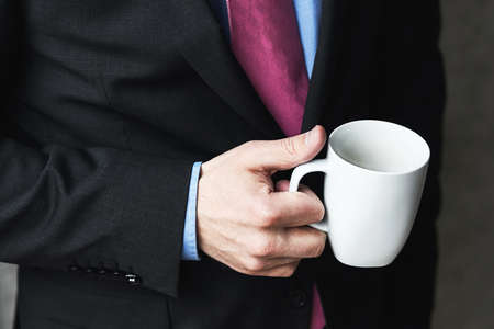 Business man in a business suit and a cup of coffeeの写真素材