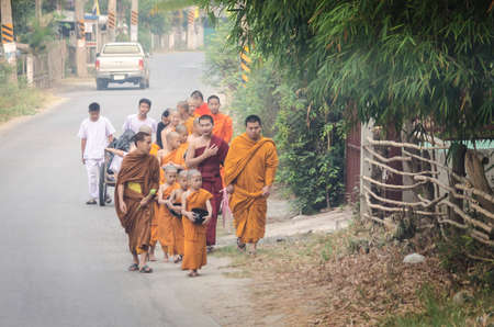 Young monk come to get some food from the buddismのeditorial素材