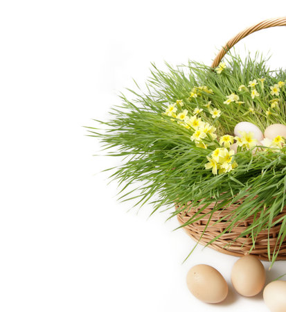 easter eggs in a basket with grass and flowers