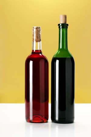 two bottles of wine on yellow backgroundの写真素材
