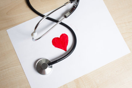 Red heart and a stethoscope on the deskの写真素材