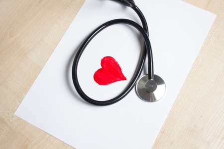 Red heart and a stethoscope on the deskの写真素材