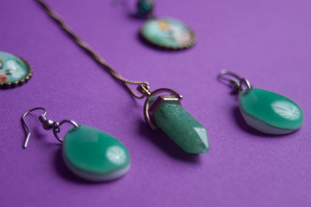two pairs of green earrings and a green pendantの写真素材