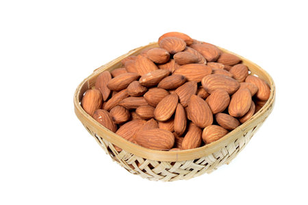Almonds in a wooden basket with heap isolated on a white backgroundの写真素材