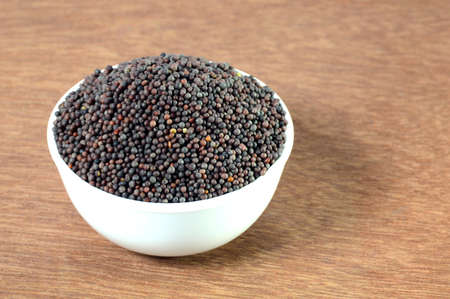 Brown Mustard Seeds in bowl on wooden backgroundの写真素材
