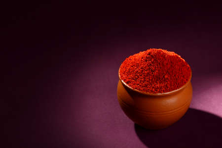 Red Chili Pepper powder in clay pot on dark backgroundの写真素材