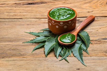 Medicinal Neem leaves with paste on wooden background