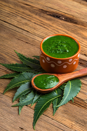 Medicinal Neem leaves with paste on wooden background