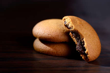 Biscuits filled with chocolate cream. Chocolate cream cookies. brown chocolate biscuits with cream filling on black background.の写真素材