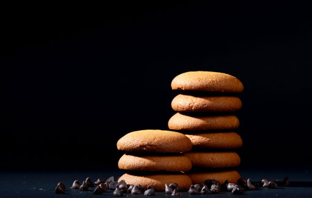 BISCUITS - Stack of delicious cream biscuits filled with chocolate cream on black background