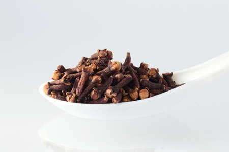 clove in spoon isolated on a white backgroundの写真素材