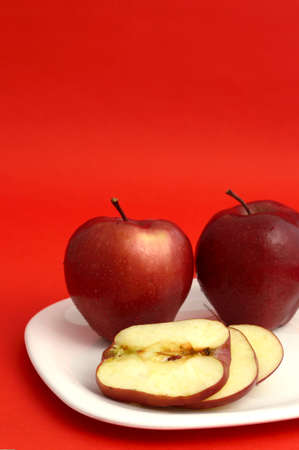 Ripe Red Apples on red backgroundの写真素材