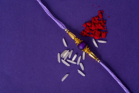 Raksha Bandhan : Rakhi with rice grains and kumkum. An Indian festive background. Traditional Indian wrist band which is a symbol of love between Brothers and Sisters.の写真素材