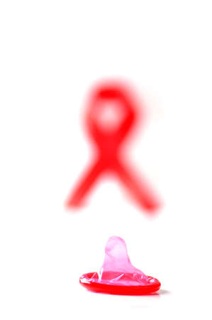 Aids ribbon and condom on white background.の写真素材