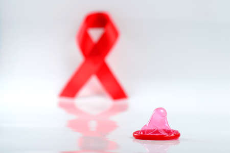 Aids ribbon and condom on white background.の写真素材