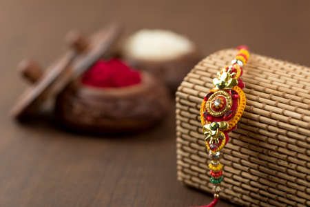 Indian festival: Raksha Bandhan background with an elegant Rakhi, Rice Grains and Kumkum. A traditional Indian wrist band which is a symbol of love between Brothers and Sisters.の写真素材