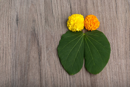 Indian Festival Dussehra, showing golden leaf (Bauhinia racemosa) and marigold flowers on a wooden...