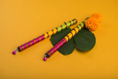 Indian Festival Dussehra and Navratri, showing golden leaf (Bauhinia racemosa) and marigold flowers with Dandiya sticks.の写真素材