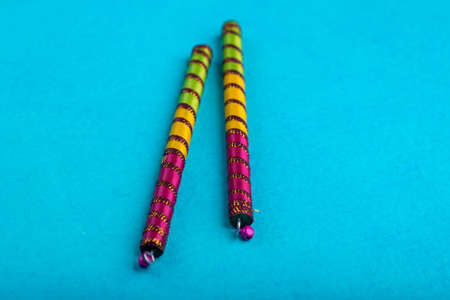 Dandiya sticks on a blue background. Raas Garba or Dandiya Raas is the traditional folk dance form the state of Gujarat & Rajasthan in India.の写真素材
