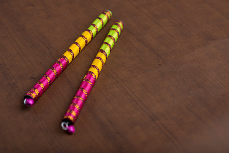 Dandiya sticks on a brown background. Raas Garba or Dandiya Raas is the traditional folk dance form...