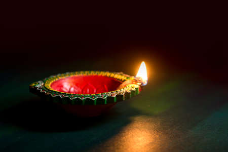Happy Diwali - Clay Diya lamps lit during Diwali celebration. Greetings Card Design of Indian Hindu Light Festival called Diwaliの写真素材