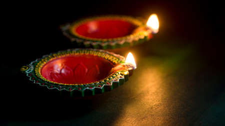 Happy Diwali - Clay Diya lamps lit during Diwali celebration. Greetings Card Design of Indian Hindu Light Festival called Diwaliの写真素材