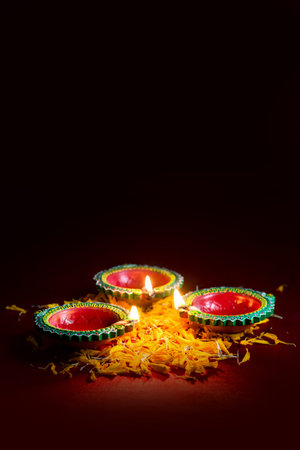 Happy Diwali - Clay Diya lamps lit during Diwali celebration. Greetings Card Design of Indian Hindu...
