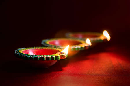 Happy Diwali - Clay Diya lamps lit during Diwali celebration. Greetings Card Design of Indian Hindu Light Festival called Diwaliの写真素材
